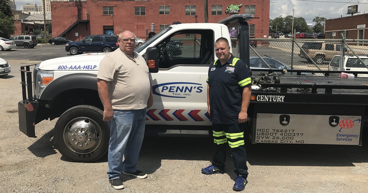 Bill Penn and driver standing beside tow truck