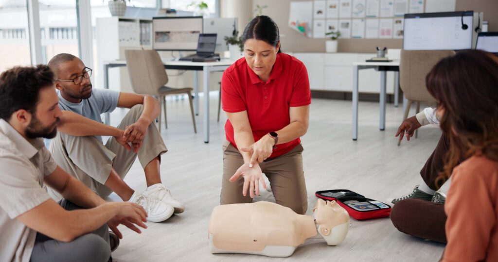 First aid, cpr training and people with mannequin for safety compliance or healthcare