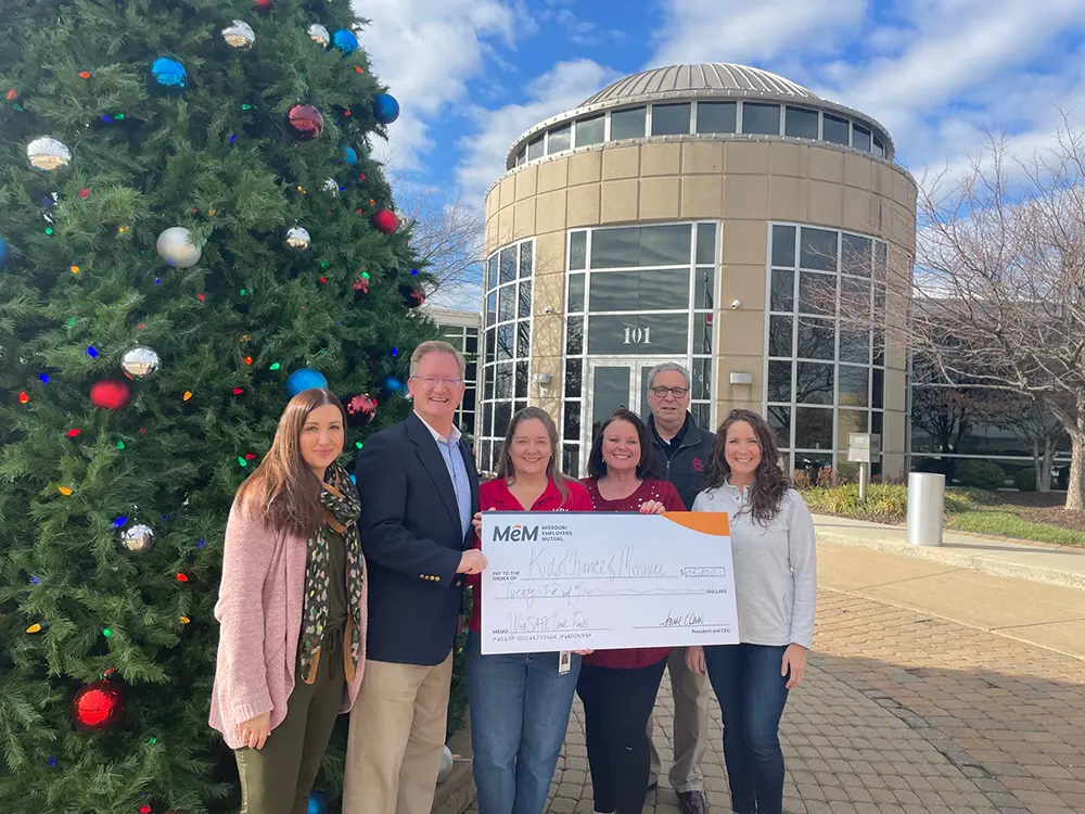 Group of people with large check.