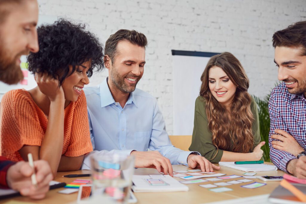 Happy coworkers developing new layout in the office around a table