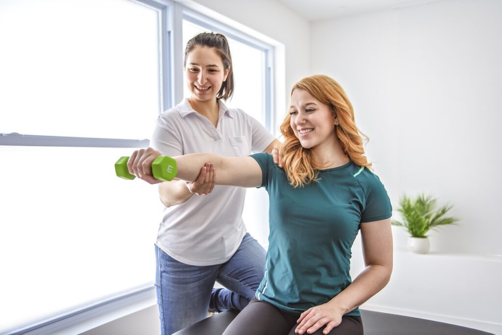 A Modern rehabilitation physiotherapy at work with client holding dumbbell