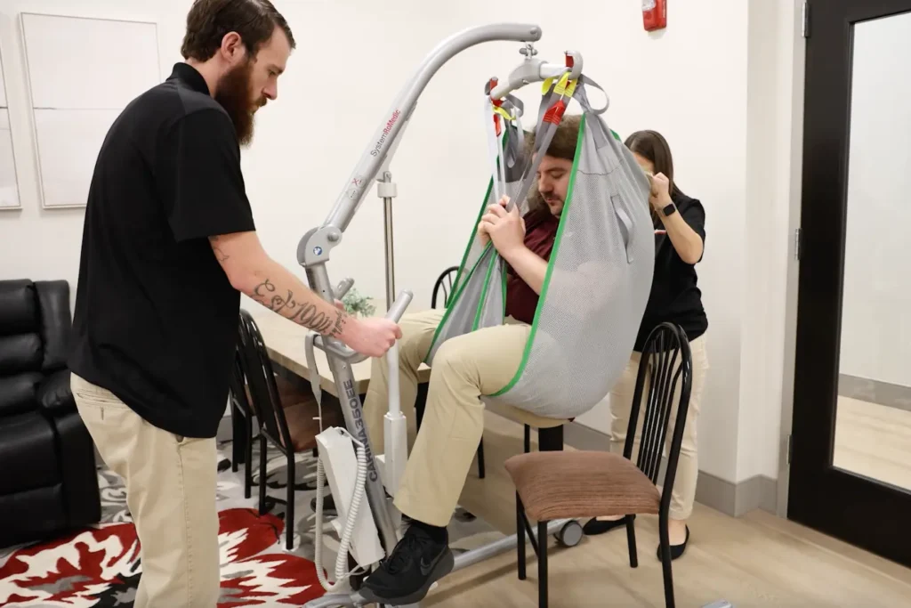 Emmaus team members practice using a patient lift.