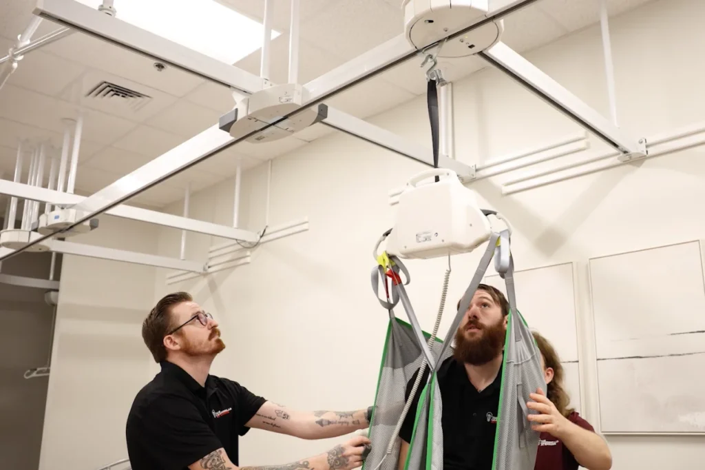 Emmaus team members operate a chair lift.