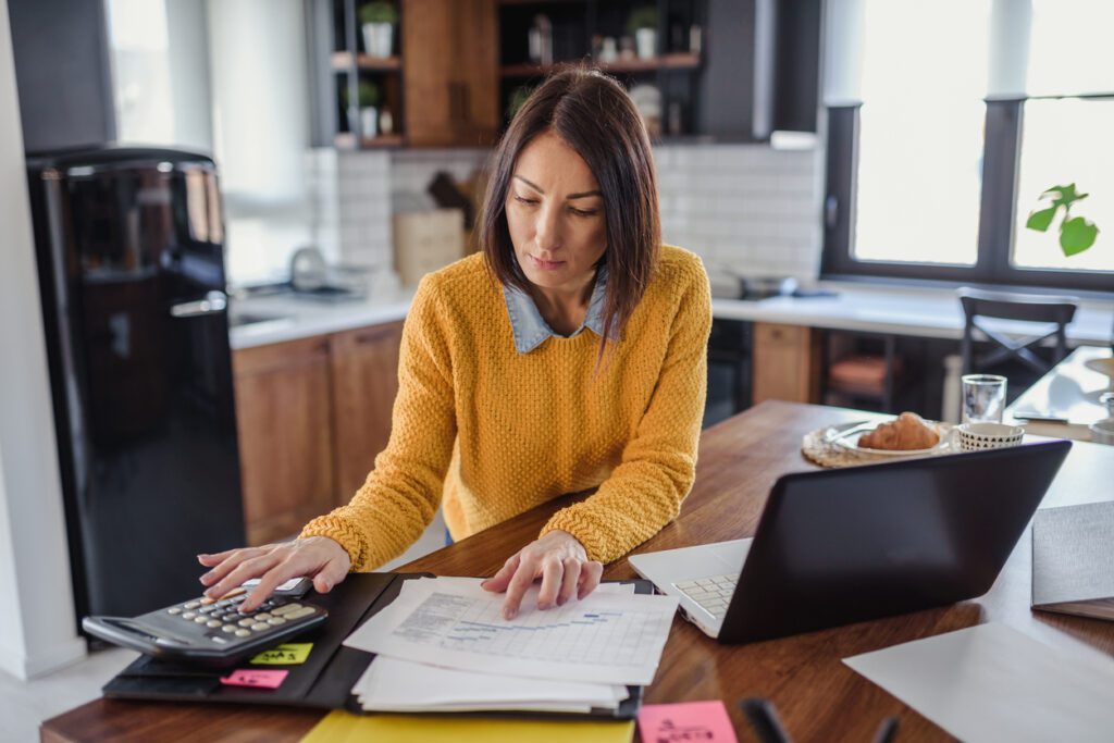 Freelance woman working in home office with laptop computer